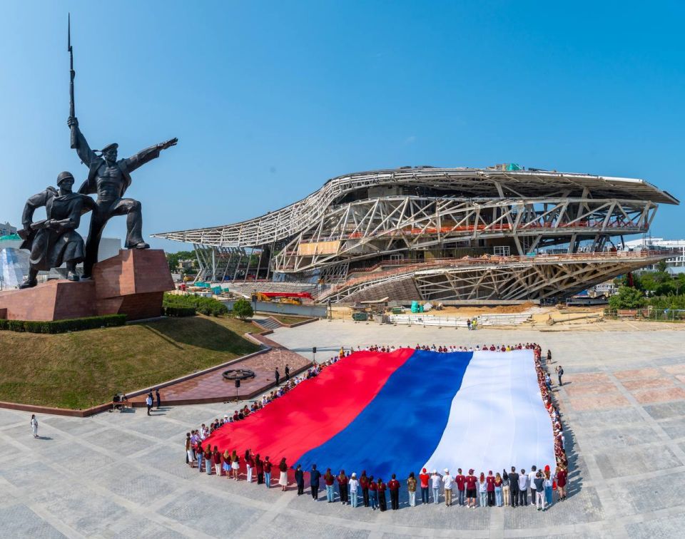 Огромный флаг России в честь праздника севастопольские студенты и школьники развернули на площадке возле памятника Солдату и Матросу
