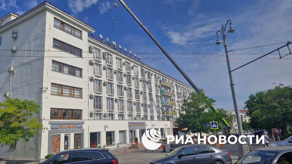 Надпись "Украина" демонтировали с крыши отеля на площади Ушакова в центре Севастополя, передает корреспондент РИА Новости (фото снизу - из соцсетей)